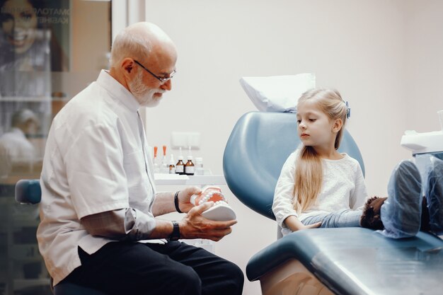 Linda niña sentada en la oficina del dentista