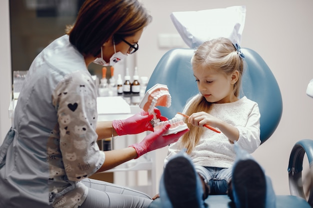 Linda niña sentada en la oficina del dentista