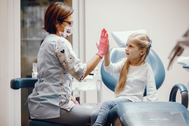 Linda niña sentada en la oficina del dentista