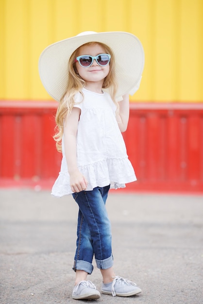 Foto gratuita linda niña con sombrero con mochila al aire libre