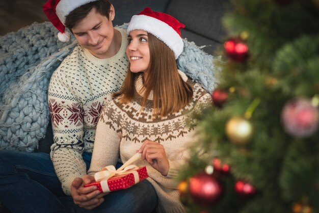 Linda pareja abriendo regalo de navidad