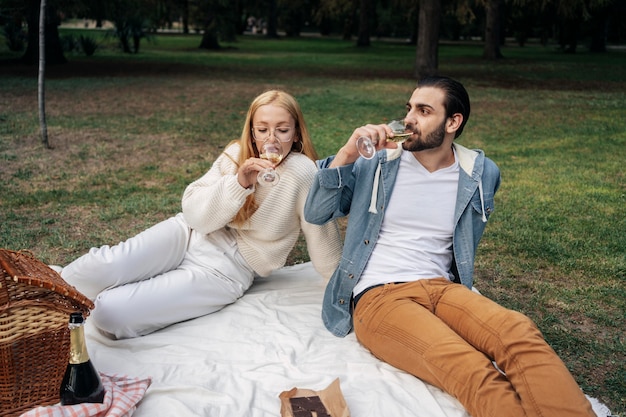 Foto gratuita linda pareja bebiendo vino mientras hace un picnic