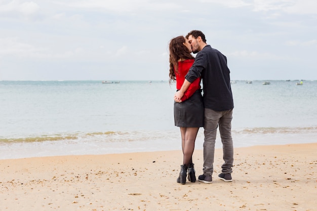 Linda pareja besándose en la orilla del mar