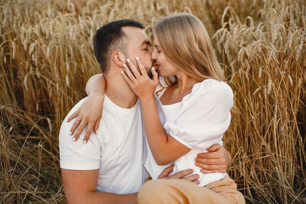 Linda pareja en un campo. Dama con blusa blanca. Chico con una camisa blanca