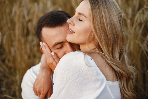 Linda pareja en un campo. Dama con blusa blanca. Chico con una camisa blanca