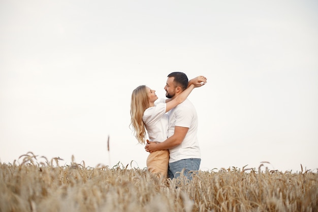 Linda pareja en un campo. Dama con blusa blanca. Chico con una camisa blanca