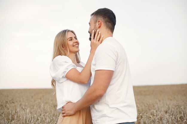 Linda pareja en un campo. Dama con blusa blanca. Chico con una camisa blanca