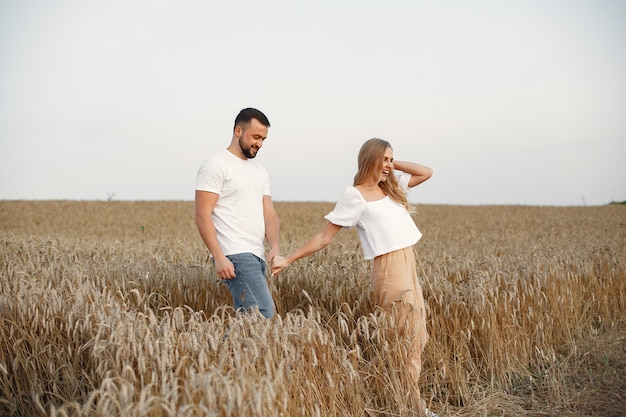 Linda pareja en un campo. Dama con blusa blanca. Chico con una camisa blanca