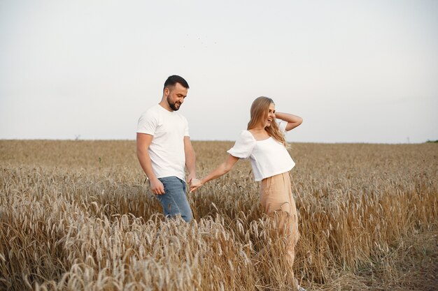 Linda pareja en un campo. Dama con blusa blanca. Chico con una camisa blanca