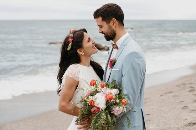 Foto gratuita linda pareja celebrando su boda en la playa