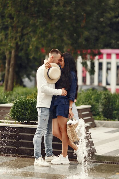 Linda pareja en una ciudad. Hombre con camisa blanca. La gente camina.