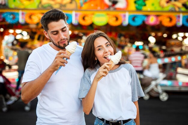 Linda pareja comiendo helados en la feria