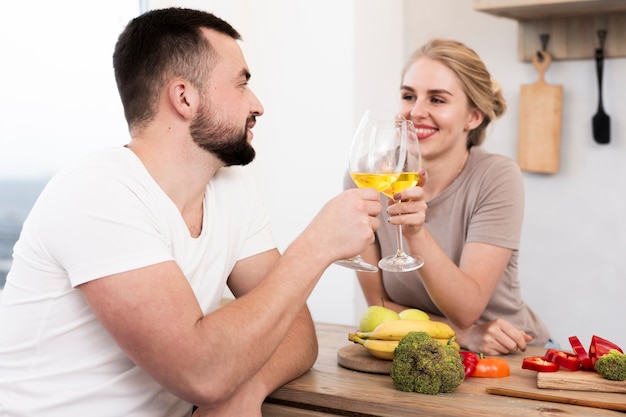 Linda pareja comiendo verduras y bebiendo juntos