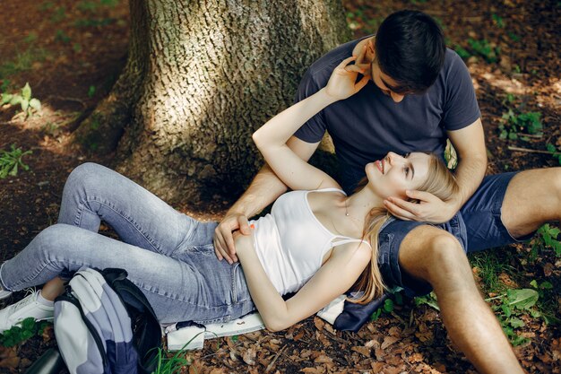 Linda pareja descansa en un bosque de verano