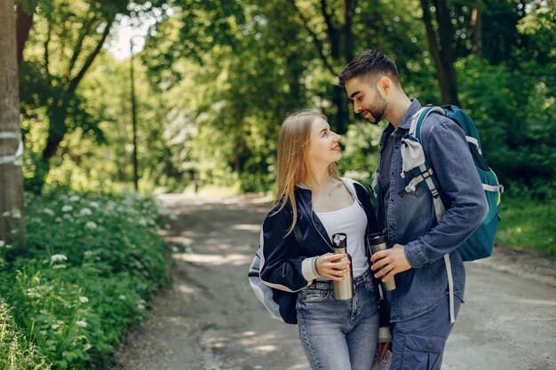 Linda pareja descansa en un bosque de verano