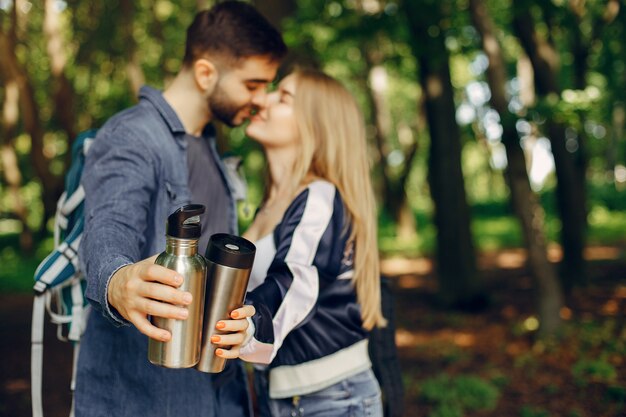 Linda pareja descansa en un bosque de verano