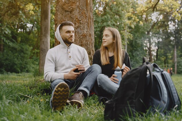 Linda pareja descansa en un bosque de verano