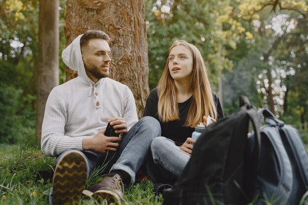 Linda pareja descansa en un bosque de verano