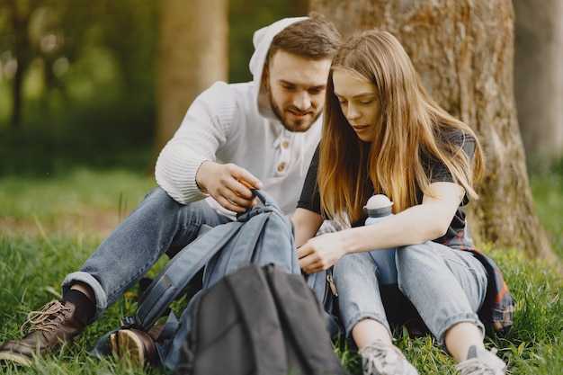 Linda pareja descansa en un bosque de verano