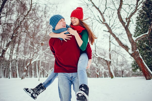 Linda pareja divertirse en un parque de invierno