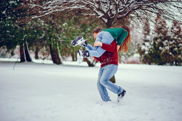 Linda pareja divertirse en un parque de invierno