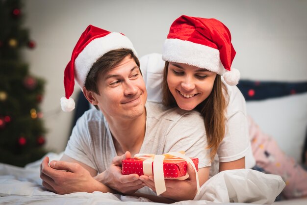 Linda pareja en dormitorio con regalo