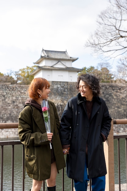 Foto gratuita linda pareja japonesa en una cita con flor de rosa