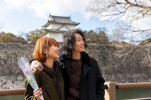 Foto gratuita linda pareja japonesa en una cita con flor de rosa