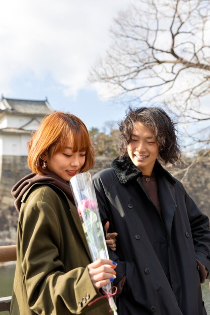 Linda pareja japonesa en una cita con flor de rosa