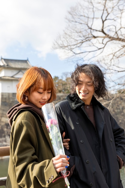 Linda pareja japonesa en una cita con flor de rosa