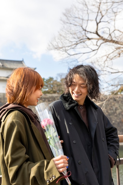 Linda pareja japonesa en una cita con flor de rosa