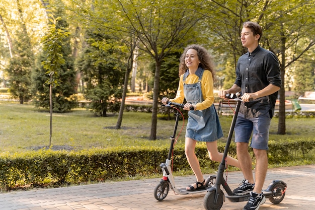 Linda pareja joven montando scooter al aire libre