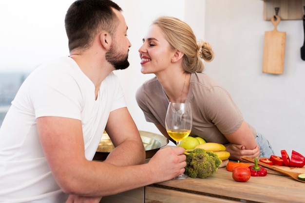 Linda pareja joven sentados juntos en la cocina