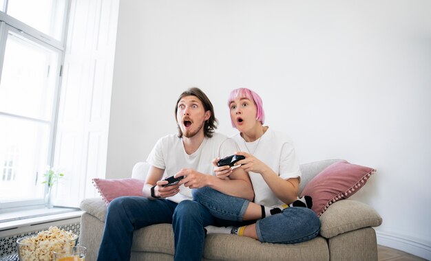 Linda pareja jugando videojuegos en el sofá