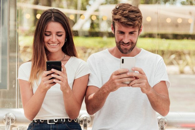 Linda pareja con mensajes de texto de teléfonos