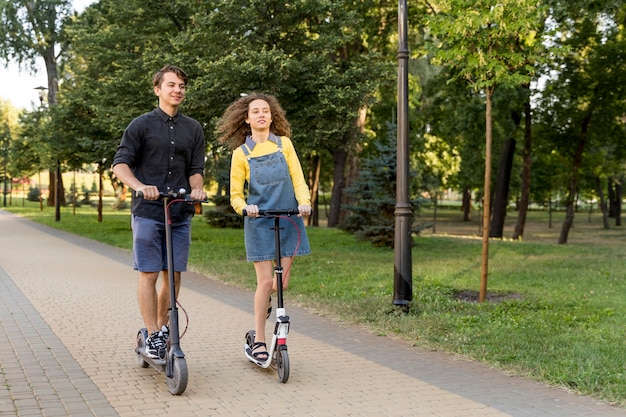 Linda pareja montando scooter juntos