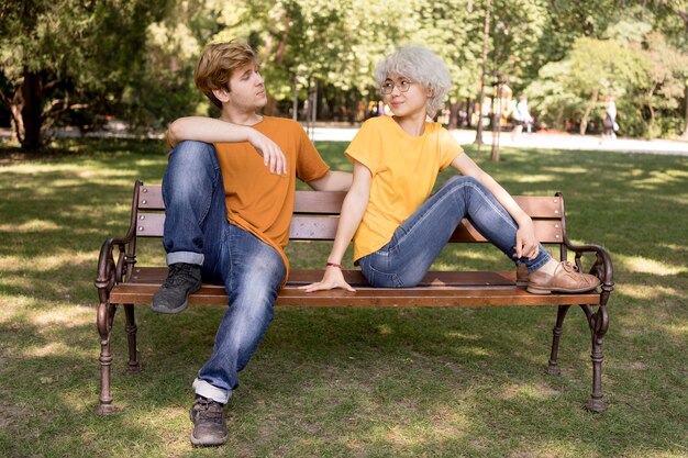 Linda pareja relajándose en el parque en un banco