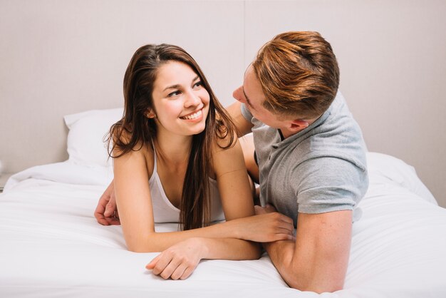 Linda pareja en ropa de dormir abrazando en la cama