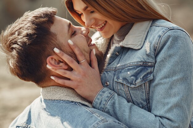 Linda pareja en ropa de jeans en un campo de primavera