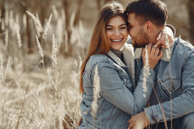 Linda pareja en ropa de jeans en un campo de primavera