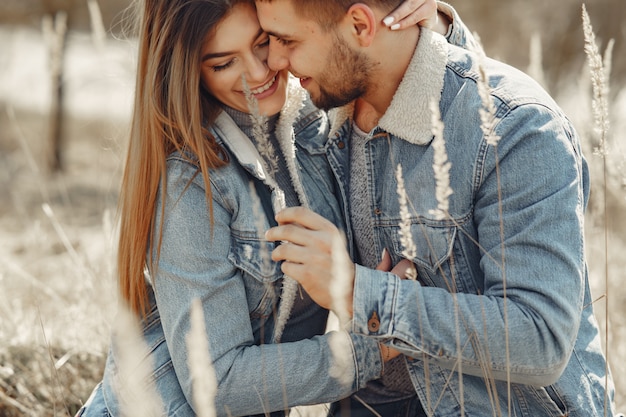 Linda pareja en ropa de jeans en un campo de primavera