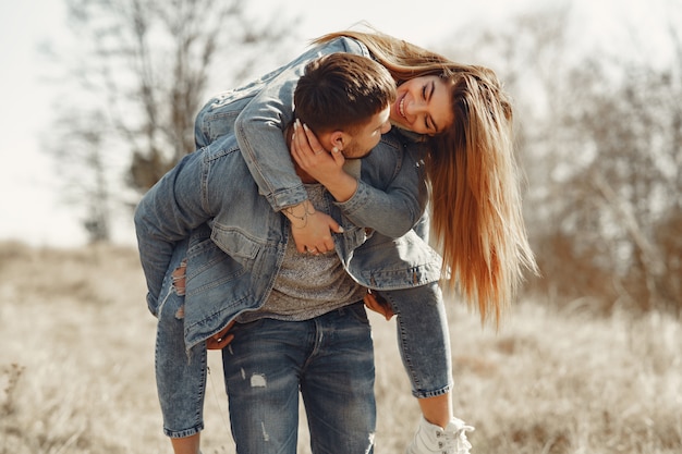 Linda pareja en ropa de jeans en un campo de primavera