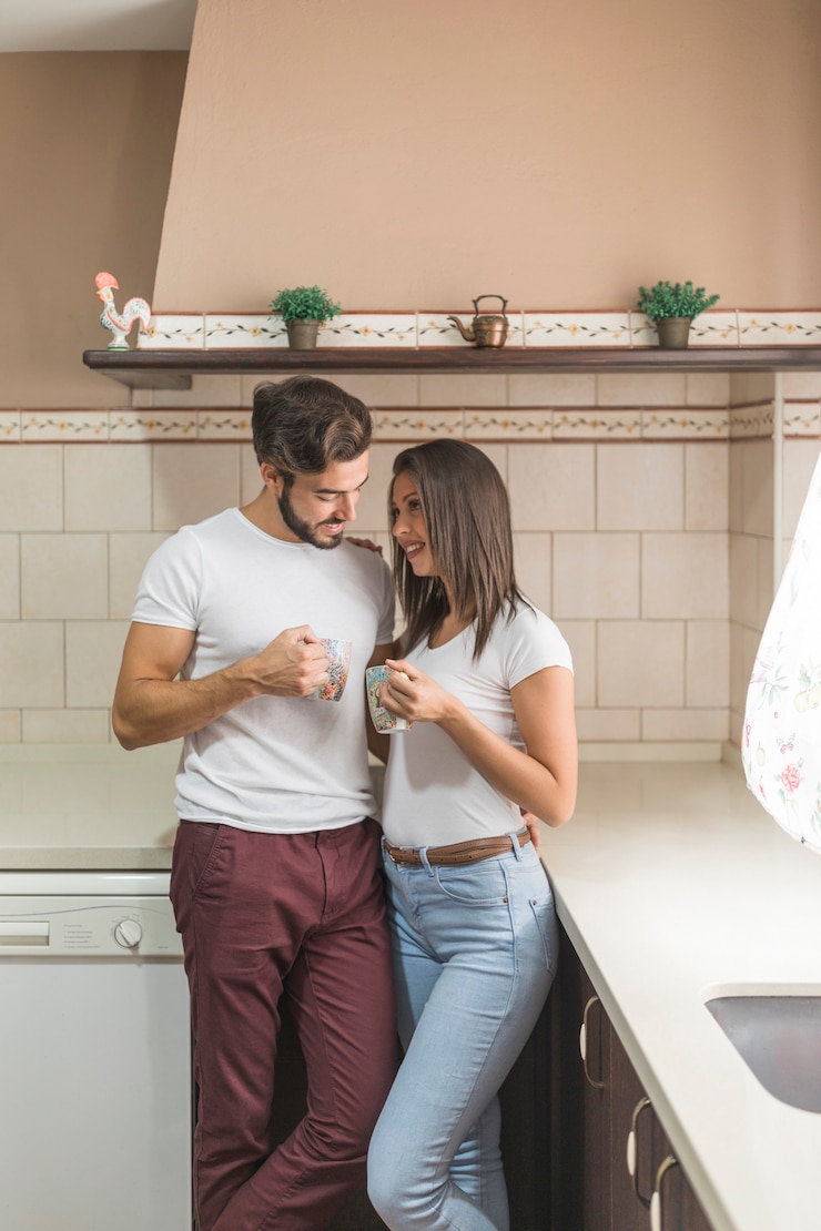 Foto gratuito linda pareja con tazas en la elegante cocina