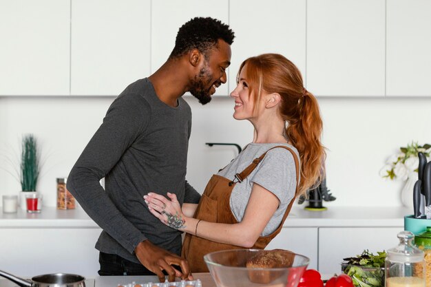 Linda pareja de tiro medio en la cocina