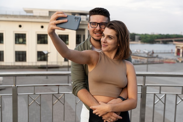 Linda pareja de tiro medio tomando selfie