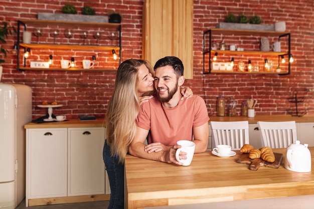 Linda pareja tomando el desayuno en la cocina