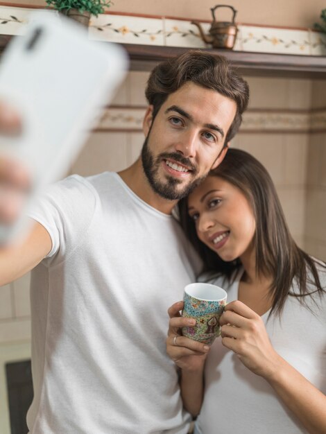 Linda pareja tomando selfie durante el desayuno