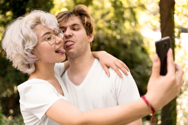 Linda pareja tomando un selfie y haciendo muecas