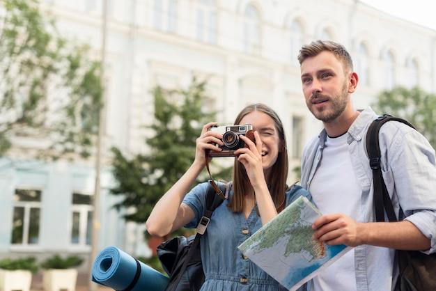 Linda pareja de turistas tomando fotos con la cámara