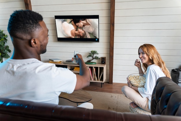 Foto gratuita linda pareja viendo una película en servicio de streaming